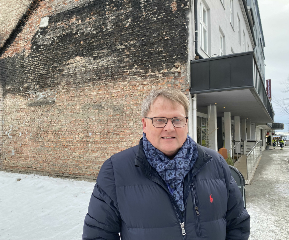 TYDELIGE SPOR: Hotelldirektør Vidar Haugen har sterke minner fra det som skjedde i nabobygget for et drøyt år siden. Det er tydelige spor etter flammehavet i murveggen som ligger inntil hotellet.
