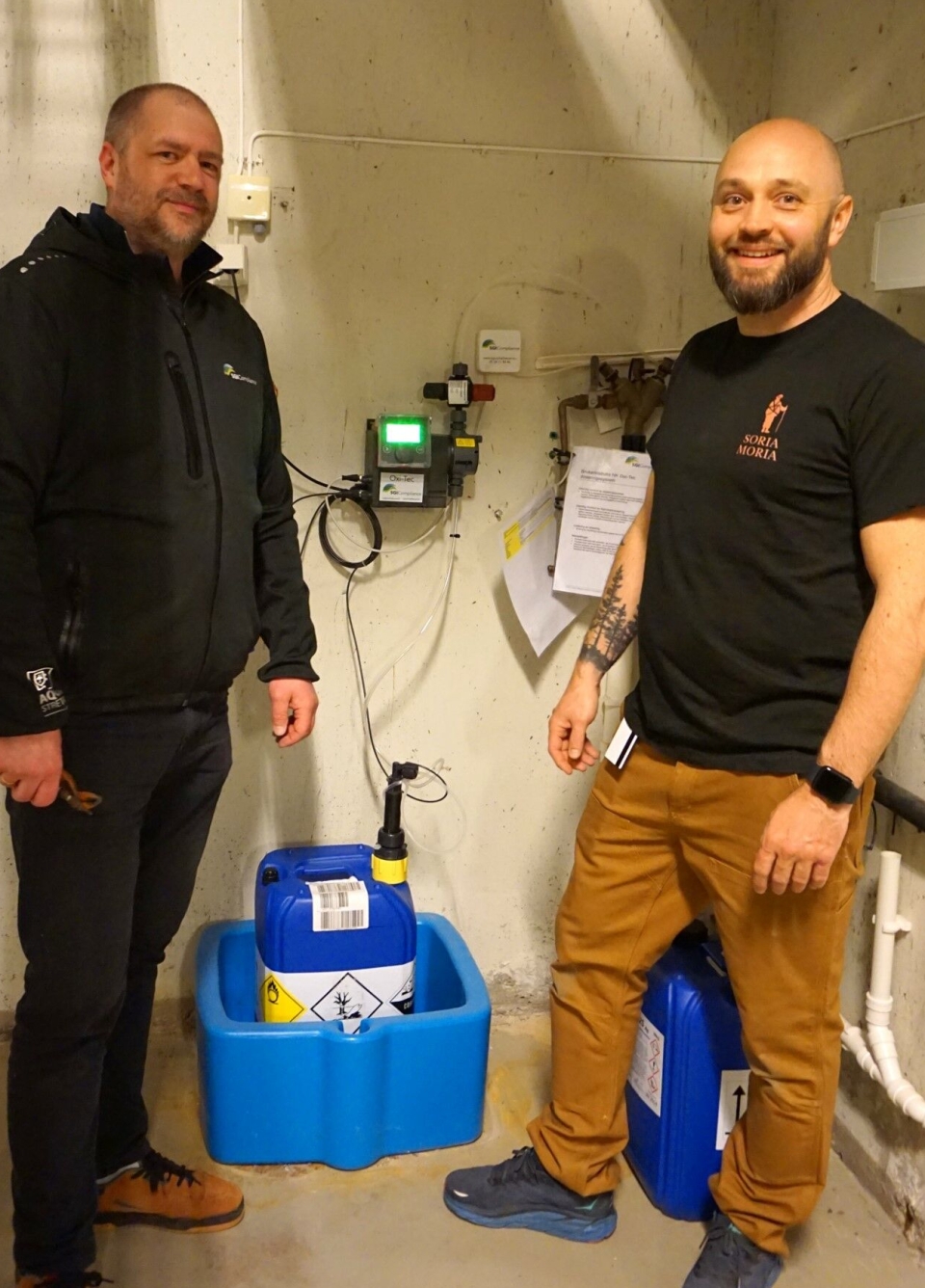 Serviceleder (SGI) Andreas Stensrud sammen med teknisk sjef Timothy Maclean fra Soria Moria, hvor de står foran SGI Oxi-Tec doseringsanlegg.